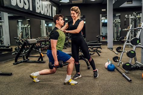 Female Personal Trainer Instructing Young Man Stock Photo Download
