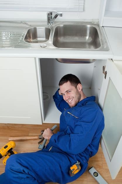 Premium Photo Portrait Of A Smiling Repairman Fixing A Sink