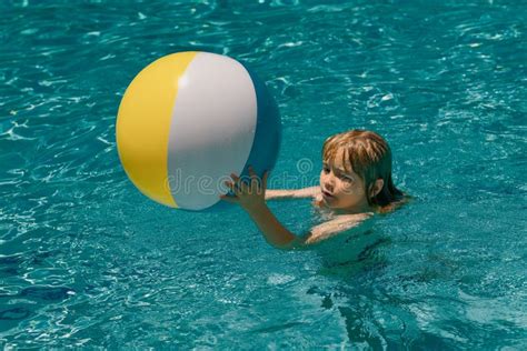Kid Boy In Swimming Pool On Inflatable Ring Children Swim With Orange