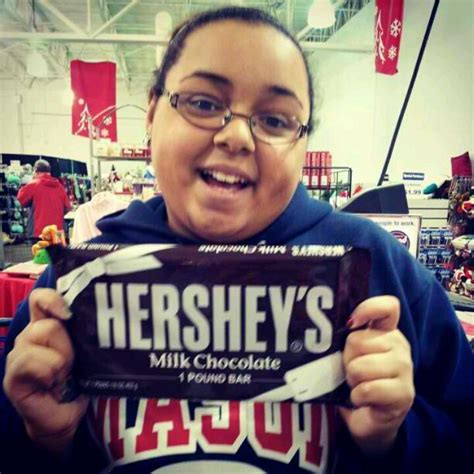 A Woman Holding Up A Hershey S Milk Chocolate Bar