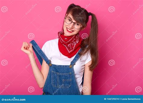 Playful Smiling Girl Touches Her Denim Overalls Being In High Spirits Cheerful Long Haired