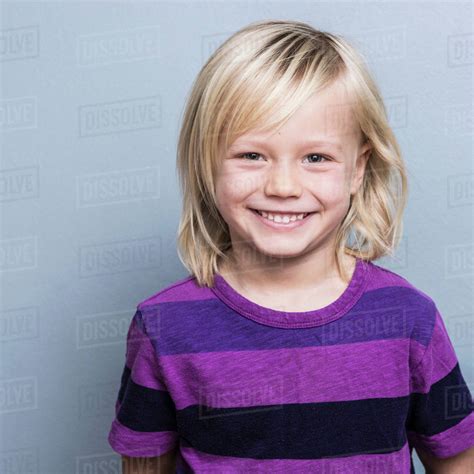 Portrait Of Blonde Haired Boy Looking At Camera Smiling Stock Photo