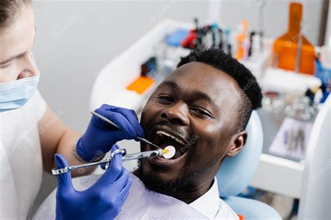 El Dentista Inyecta Una Jeringa Con Anestesia En La Boca De Un Hombre