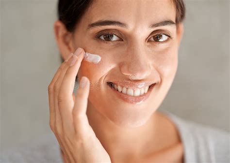 Taking Care Of Her Skin A Beautiful Woman Applying Moisturizer To Her Face Stock Image Image