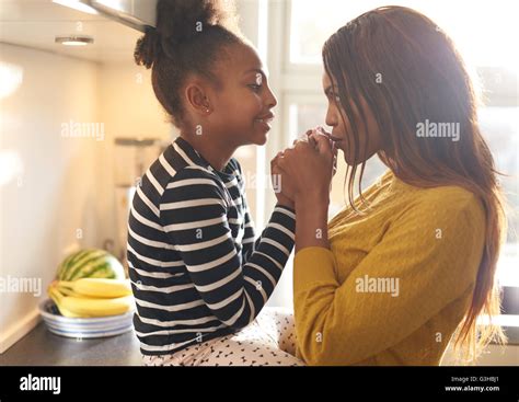 Madre Besando A Su Hija En Casa En La Cocina La Mujer Negra Fotografía