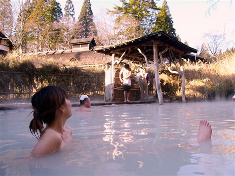 Three People In A Hot Tub With Trees In The Background