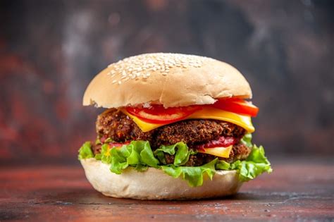 Saboroso hambúrguer de carne com queijo e salada de frente no fundo