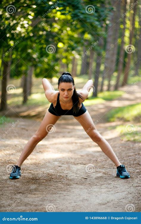 Brunette Slim Young Woman In Sportswear Workout Outside Doing Stretching Exercises Of Body In