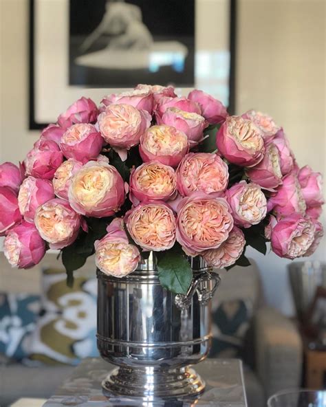 A Vase Filled With Pink Flowers Sitting On Top Of A Table Next To A Couch