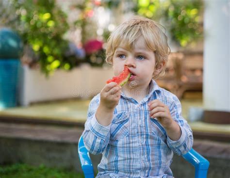 Adorable Little Toddler Boy With Blond Hairs Eating Watermelon I Stock
