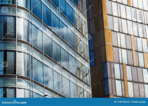 Modern Office Buildings With Glass Windows And Sky Reflections On A