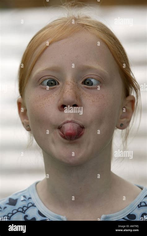 7 Year Old Girl With Red Hair Grimacing Showing Its Tongue And Stock