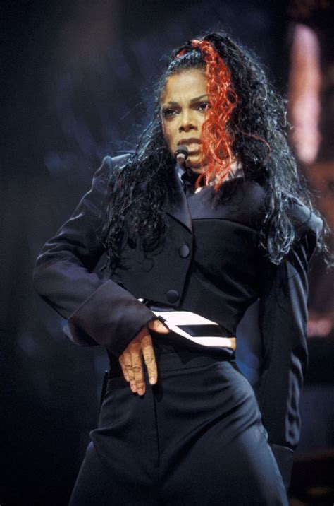 A Woman With Red Hair And Black Clothes On Stage