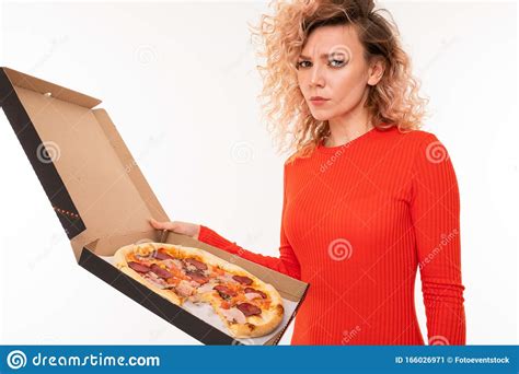 European Curly Blond Girl In A Red Dress Holds A Box Of Pizza On A