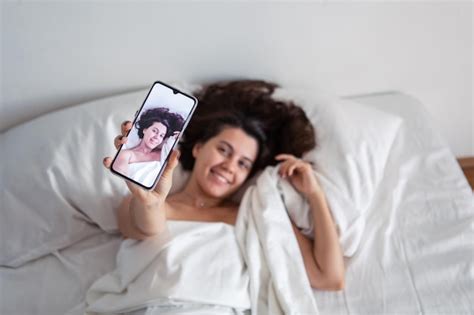 Premium Photo Woman Laying In Bed Taking Selfie On The Phone