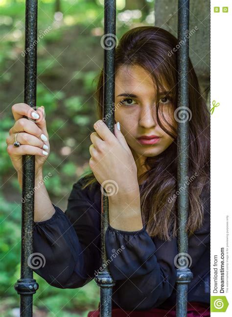 Young Charming Teenager Girl with Long Dark Hair Sitting Behind Bars in ...