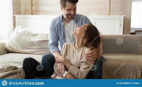 Happy Loving Spouses Cuddling Smiling Looking In Eyes Indoors Stock