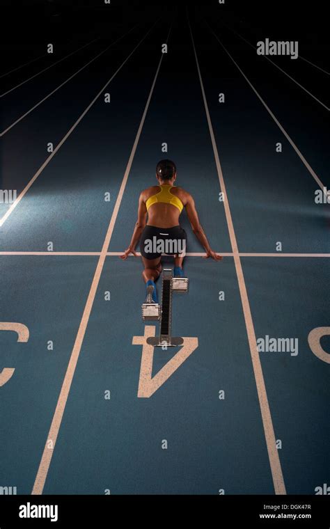 Professional Female Athlete Sprinting Off Blocks High Res Stock Photo