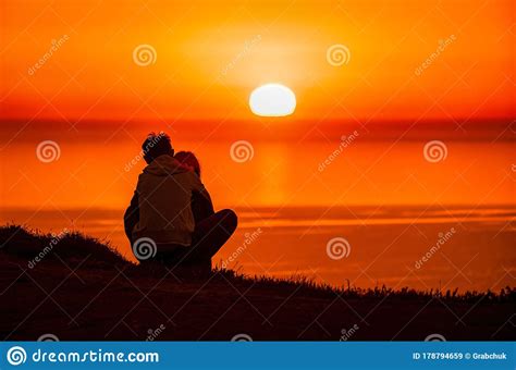 A Red Burning Sunset Over The Sea With The Silhouette Of A
