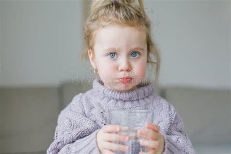 A Little Girl Holds A Glass Of Water Drinks Stock Image Image Of