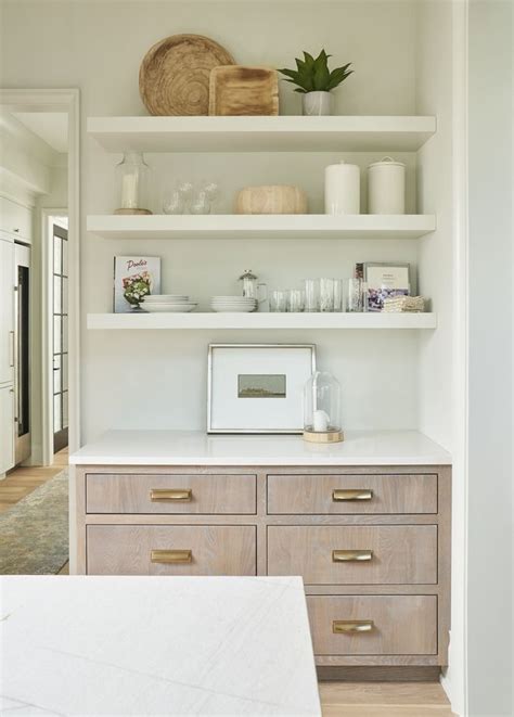Stained oak floating shelves on white subway tiles above white quartz countertops in a transitional kitchen design. Inspiring Charlotte Home Tour | Floating shelves kitchen ...