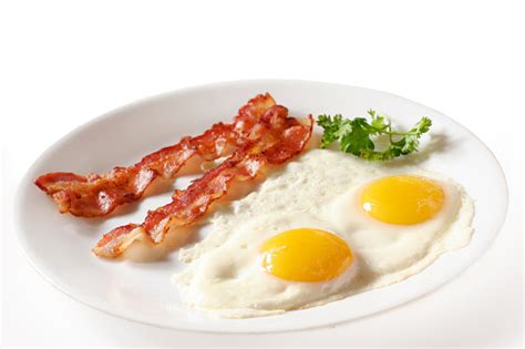 Two Eggs Over Easy With Bacon On White Plate Stock Photo Download