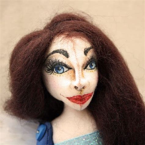 a close up of a doll with long brown hair and makeup on it s face