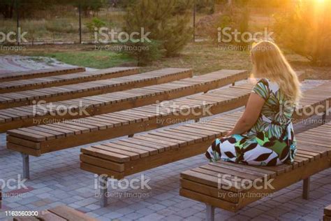 La Chica Sentada Sola En Su Espalda Entre Muchos Bancos Foto De Stock Y