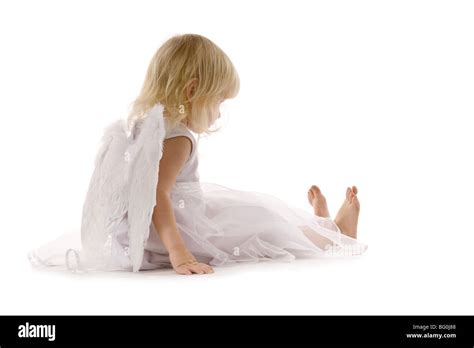 Little Girl Sadly Sitting In White Dress And Angel Wings On The Back
