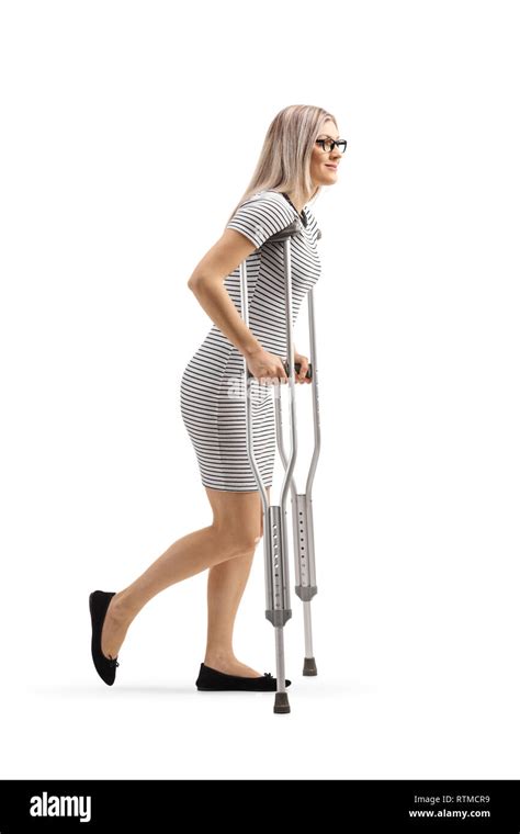 Full Length Shot Of A Young Woman Walking With Crutches Isolated On