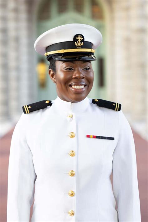 A Woman In Uniform Is Smiling For The Camera