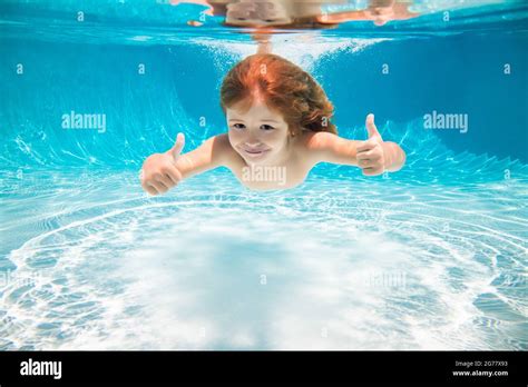 Kid Swim Underwater In Pool Child Boy Swimming Under Water With Thumbs