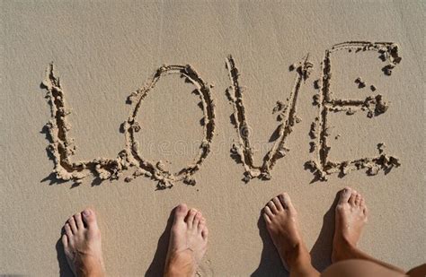 Love Inscription On Summer Sandy Beach With Coupleand X27s Foots Near