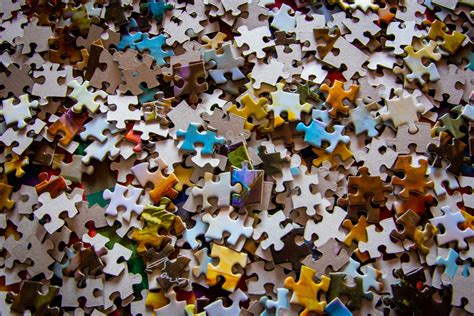 Assembling jigsaw puzzles is a great pastime that can be both relaxing and challenging. 2 Hands Holding 1 Jigsaw Puzzle Piece Each · Free Stock Photo