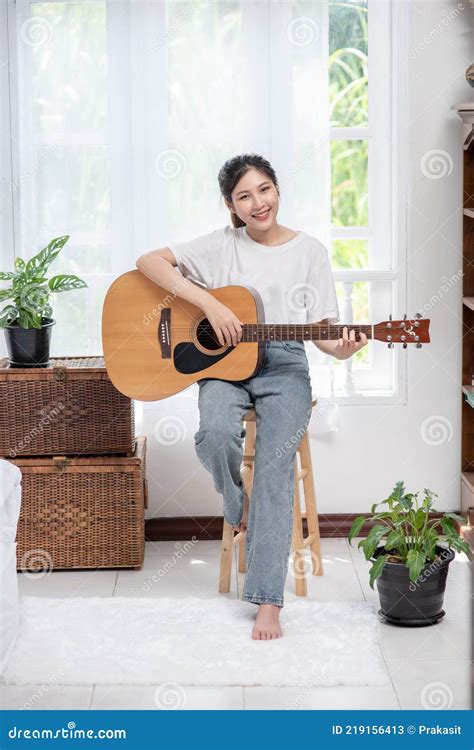 The Girl Is Sitting And Playing The Guitar On The Chair Stock Image Image Of Chair Relax
