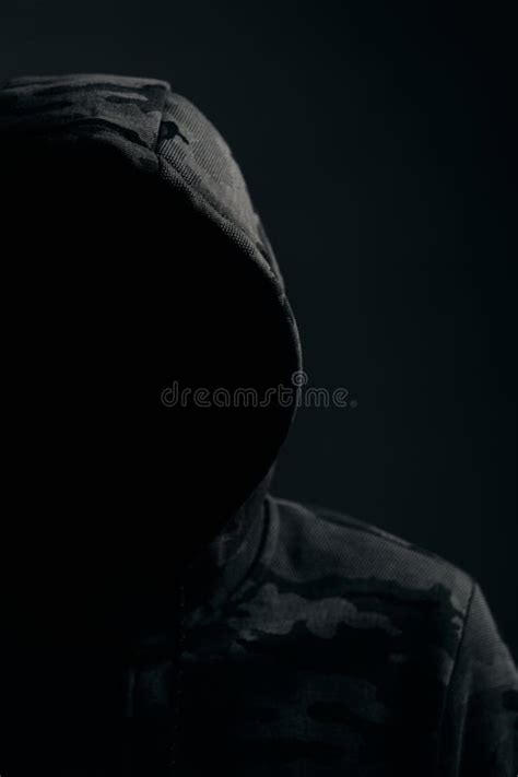 Man In Dark Camouflage Hoodie With Covered Face Dark Background Hacker