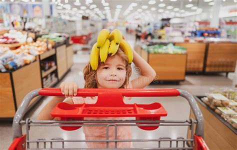 Funny Kid With Shopping Cart Buying Food At Grocery Store Or