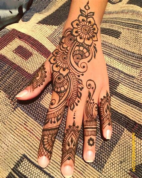 a woman s hand with henna tattoos on it
