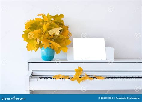 Maple Leaves On The Piano In A Blue Vase The Concept Of Autumn