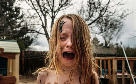 Close Up Of Girl Crying And Screaming With Mud On Face At Backyard