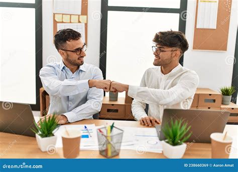 Two Hispanic Men Business Workers Smiling Confident Bumping Fists Working At Office Stock Image