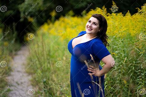 Happy Plus Size Fashion Model In Blue Dress With A Deep Neckline
