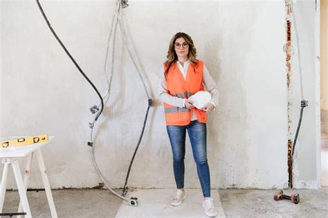 professional confident architect woman in construction site holding blueprints home renovation
