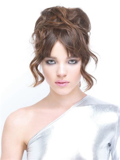 This style will work for all face shapes and straight to wavy hair types. Modern updo with piled curls and straight bangs