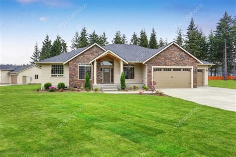 Luxury One Level House Exterior With Brick Trim And Garage Stock Photo