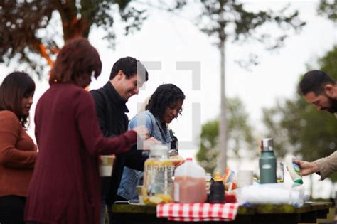 Friends Gathered Around A Table Getting Food At — Photo — Lightstock