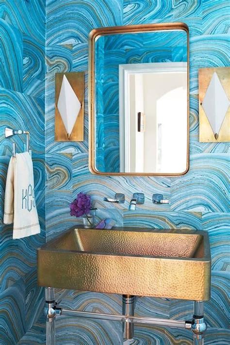 A Bathroom With Blue And Gold Wallpaper On The Walls Sink And Mirror