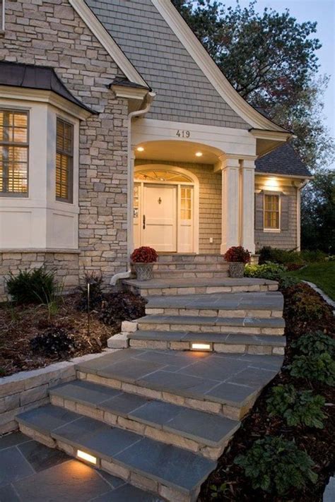 A House With Steps Leading Up To The Front Door And Lights On Either