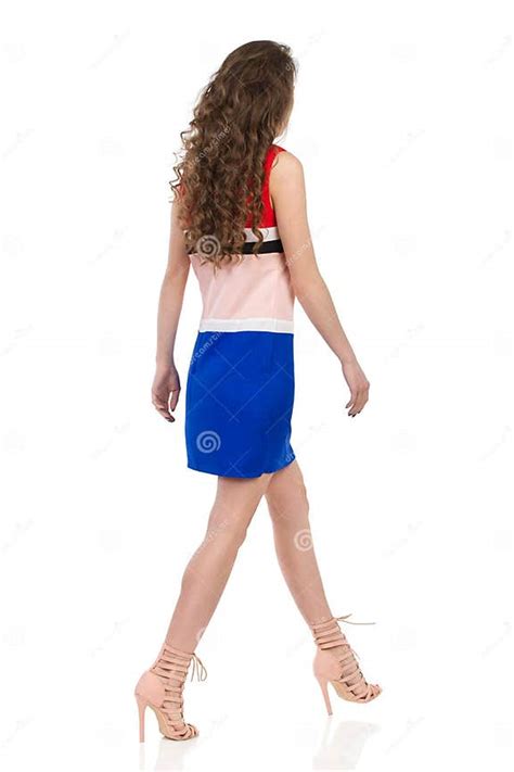 Walking Woman In Mini Dress And High Heels Rear Side View Stock Photo