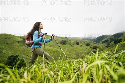 Smiling Mixed Race Woman Hiking With Walking Sticks Photo12 Tetra